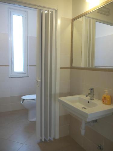 a bathroom with a sink and a toilet and a mirror at Hotel Flora in Celle Ligure
