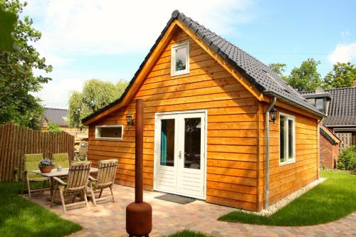 a small wooden cabin with a table and chairs at Aan het Diepje in Lettelbert