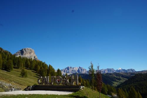 a sign on a hill with mountains in the background at Chalet Cogolara in Colfosco