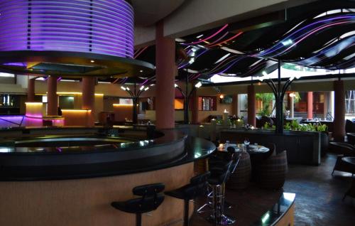 a restaurant with a bar with stools at Malligi,Hampi in Hospet