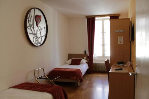 una camera d'albergo con due letti e un orologio a parete di Hostellerie du XVI Siècle a Nyon