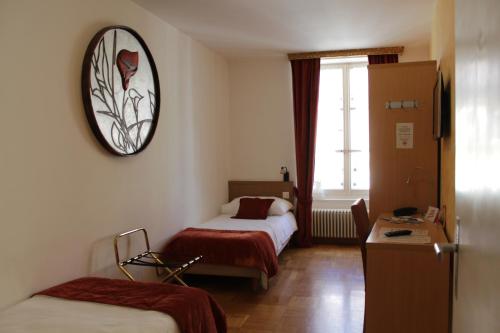 ein Hotelzimmer mit 2 Betten und einer Uhr an der Wand in der Unterkunft Hostellerie du XVI Siècle in Nyon