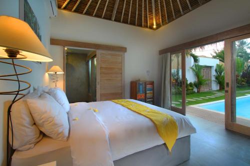 een slaapkamer met een bed en een zwembad bij Villa Thiara by Optimum Bali Villas in Seminyak