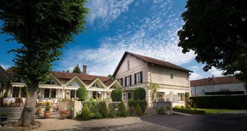 ein großes weißes Haus mit einem Baum davor in der Unterkunft Hôtel & Restaurant Le Relais d'Aumale in Orry-la-Ville