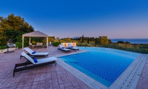 a swimming pool with chairs and a gazebo at Frido Luxury Villa with Jacuzzi in Akrotiri