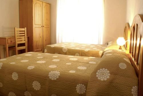 a bedroom with two beds and a window at Hostal Las Torres in Madrid