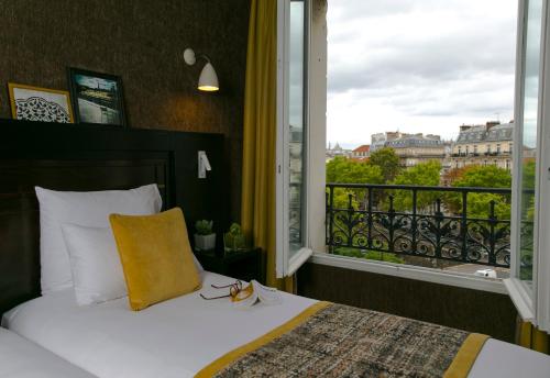 a bedroom with a bed and a large window at Hotel de Neuville Arc de Triomphe in Paris