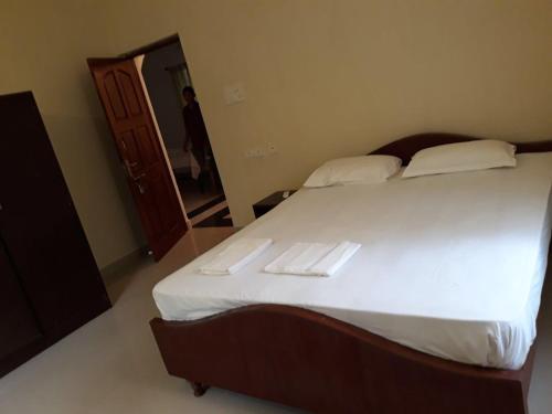 a bedroom with a large bed with two towels on it at Agnelo's Holiday Homes in Candolim