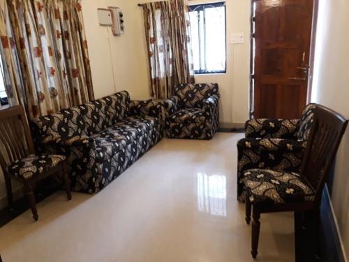 a living room with a couch and two chairs at Agnelo's Holiday Homes in Candolim