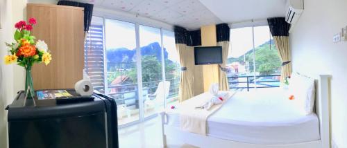 a hotel room with a bed and a large window at J Apartment in Ao Nang Beach