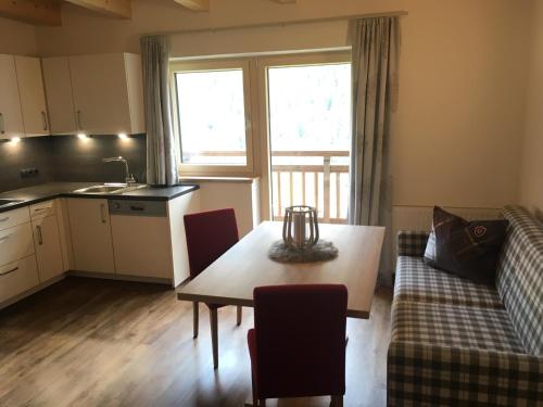a kitchen and living room with a table and a couch at Apart Hotel Arno in Sölden