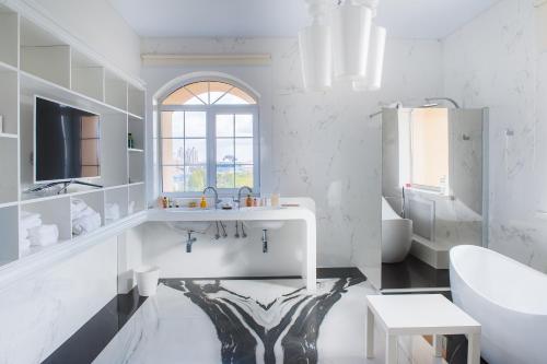 uma casa de banho branca com um lavatório e um espelho em The ONE Hotel Astana em Astana