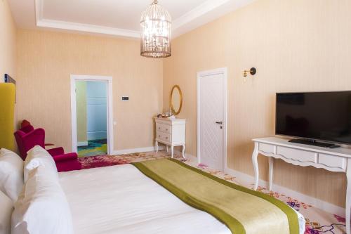 a bedroom with a large bed and a television at The ONE Hotel Astana in Astana