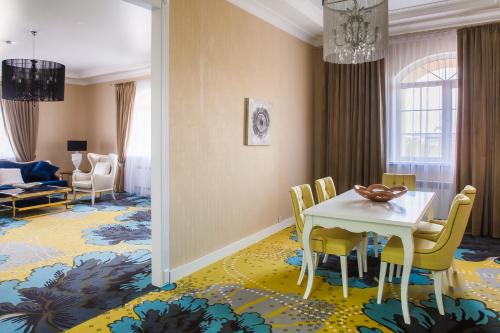 a dining room with a white table and yellow chairs at The ONE Hotel Astana in Astana