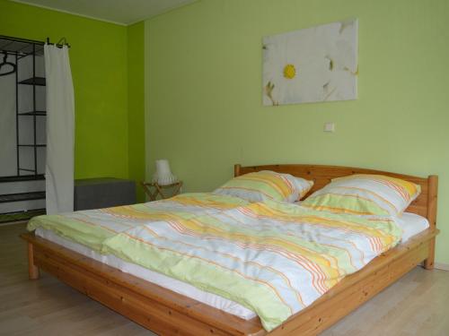 a bed in a bedroom with green walls at Ferienhaus Ritzhaupt in Angelbachtal