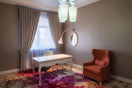 a room with a table and a chair and a mirror at The ONE Hotel Astana in Astana