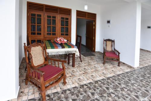 a patio with a table and chairs on a brick floor at The Lodge Unawatuna in Unawatuna