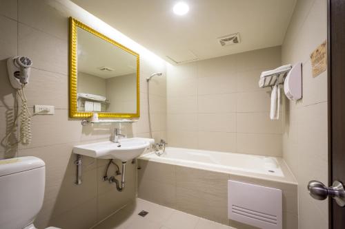 a bathroom with a sink and a toilet and a mirror at Carnival Motel in Taipei
