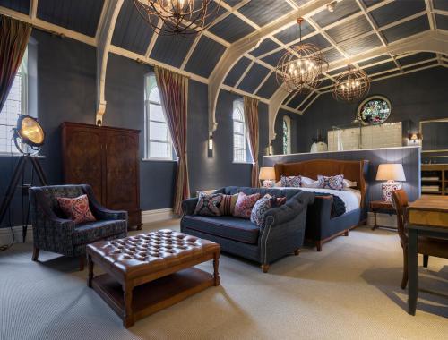 a living room with a couch and chairs and a bed at The Cookie Jar in Alnwick