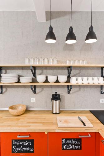 a kitchen with plates and bowls on shelves at Old Town Hostel in Berlin