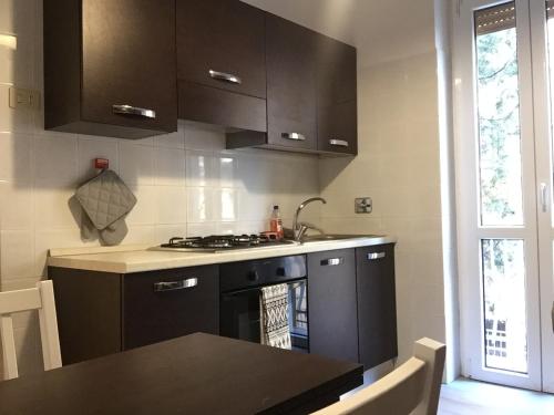 ローマにあるBenS' Houses - Villa Pamphili apartmentのキッチン(黒いキャビネット、コンロ付)