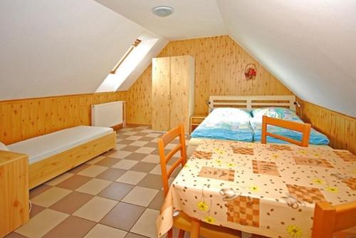 um quarto com 2 camas num sótão em Rekreačný dom Polónyi em Liptovská Teplá