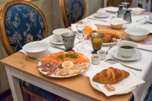 stół z talerzem jedzenia i rogalików w obiekcie Ault - Villa Aultia Hotel - baie de somme w mieście Ault