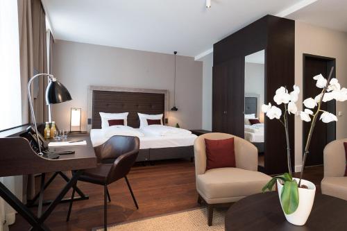 um quarto de hotel com uma cama, uma secretária e cadeiras em Hotel am Fischmarkt em Rheinberg