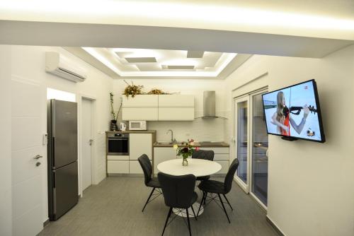 Una sala de estar con una mesa y un televisor en una pared. en Villa Benelux, en Zadar