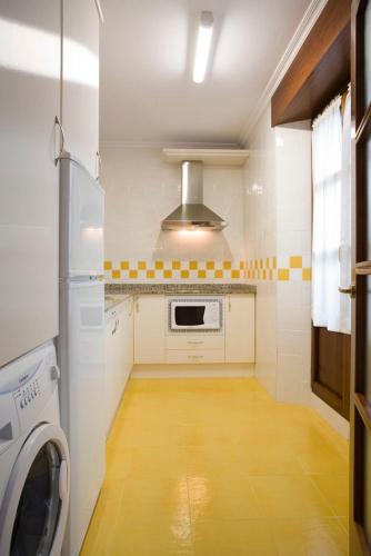 a kitchen with a washer and dryer in a room at La Fonda de Bustio in Bustio