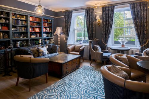 a living room with chairs and a table and bookshelves at The Cookie Jar in Alnwick