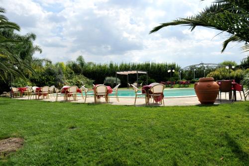 a group of chairs and tables next to a pool at B&B Lu Casale in San Cesario di Lecce