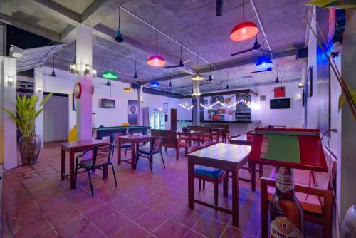 un ristorante con tavoli, sedie e tavoli da ping pong di The Siem Reap Chilled Backpacker a Siem Reap