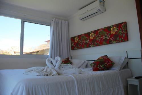 um quarto de hotel com uma cama com toalhas em Solar de Manguinhos Flat em Manguinhos