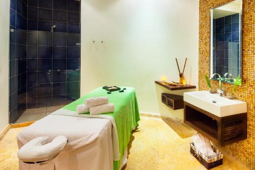 łazienka z łóżkiem, umywalką i prysznicem w obiekcie Decameron Barú - All Inclusive w mieście Playa Blanca