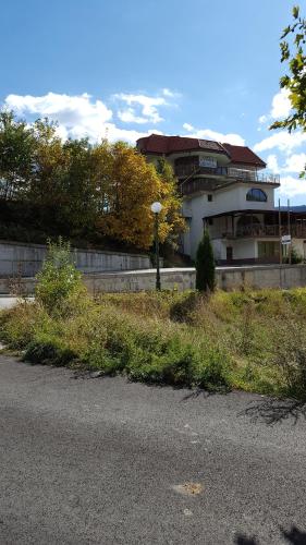 a building on the side of a road with a building at Семеен хотел Кристал in Smolyan