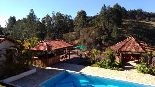 a house with a swimming pool and two gazebos at Pousada Colar de Ouro in Cunha