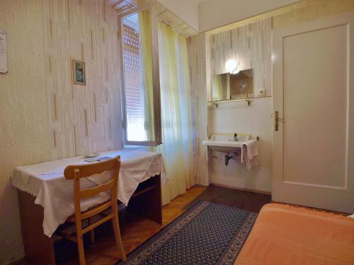 a small room with a table and a sink at Guest house Ribaric in Rab