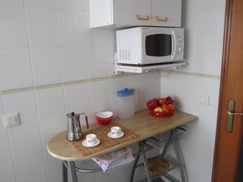 a small kitchen with a table with a microwave at Apartamento Jardin II in Gandía