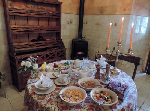 Una mesa con platos y cuencos de comida sobre ella. en Hacienda San Agustin de Callo, en Lasso