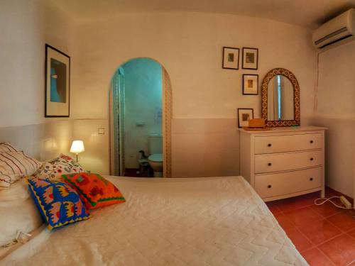a bedroom with a bed and a dresser and a mirror at Casa Jazmin Carabeo in Nerja