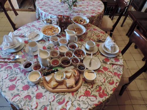 Una mesa cubierta con platos y cuencos de comida en Hacienda San Agustin de Callo, en Lasso