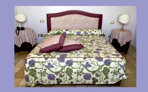 a bedroom with a bed with a green and purple comforter at Hotel Saraceno Al Faro in Taranto