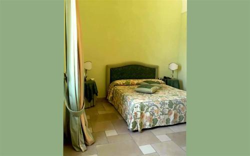 a bedroom with a bed and a tiled floor at Hotel Saraceno Al Faro in Taranto