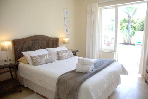 a bedroom with a bed with a teddy bear on it at Mandalay Guest House Plettenberg Bay in Plettenberg Bay