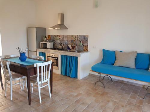 un soggiorno con tavolo e divano blu di Casa Vacanza Vendicari a Noto Marina