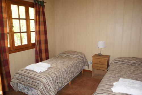 um quarto de hotel com duas camas e uma janela em El Puente Aparts em El Calafate