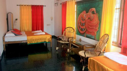 a room with two beds and a table and chairs at Indian Art Villa in Varkala