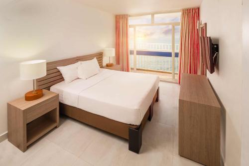 a bedroom with a bed and a large window at Decameron Cartagena - All Inclusive in Cartagena de Indias