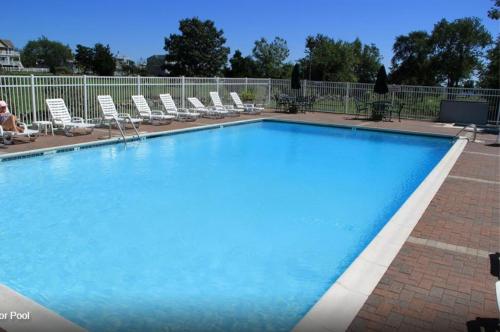 uma grande piscina azul com espreguiçadeiras à volta em Winnapaug Inn em Westerly